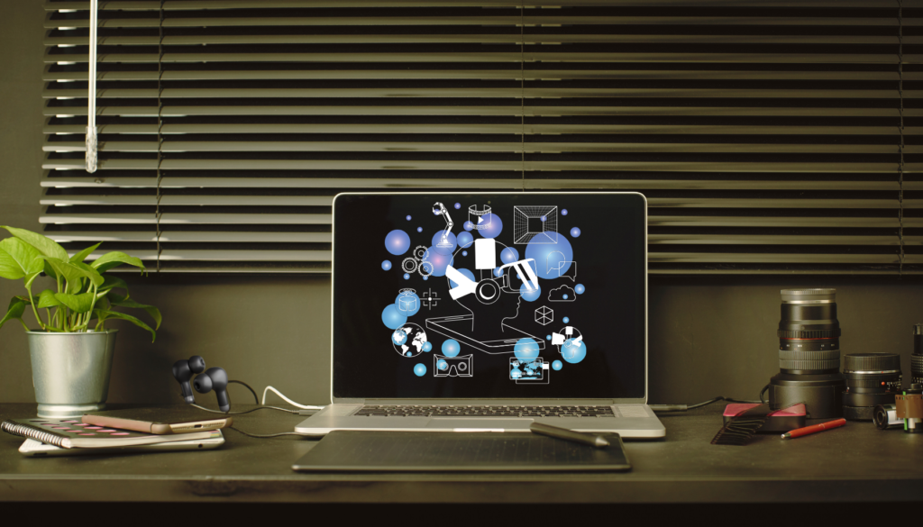 A well-designed desk setup featuring a laptop displaying futuristic VR icons, camera lenses, a potted plant, earbuds, and notebooks, creating a sense of sanity and comfort for creative professionals.