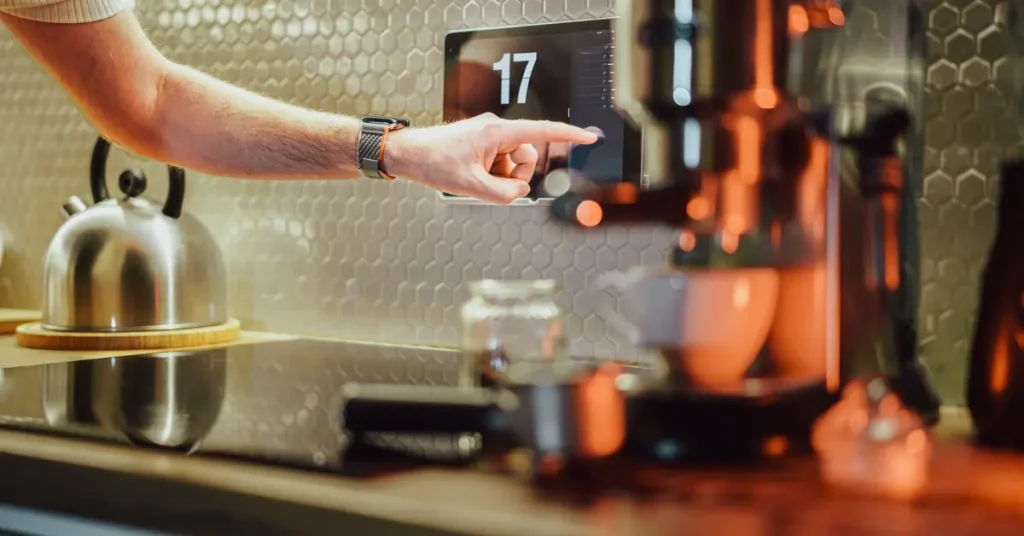 Person using AI-powered smart home device in modern kitchen, showcasing AI innovations in everyday gadgets 2025.