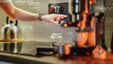 Person using AI-powered smart home device in modern kitchen, showcasing AI innovations in everyday gadgets 2025.
