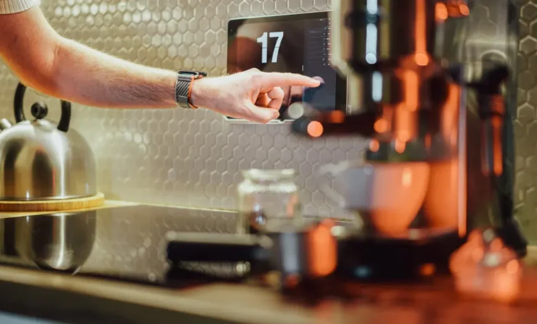 Person using AI-powered smart home device in modern kitchen, showcasing AI innovations in everyday gadgets 2025.