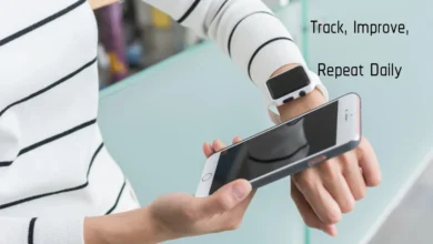 Person checking smartwatch and smartphone, showcasing better habit wearables for daily health tracking.
